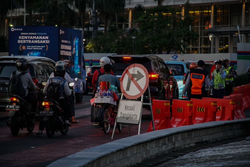 Petugas Dishub DKI Jakarta bersama Polisi Lalu Lintas mengatur lalu lintas saat penerapan uji coba rekayasa lalu lintas di kawasan Bundaran Hotel Indonesia, Jakarta, Senin, 4 Juli 2022.