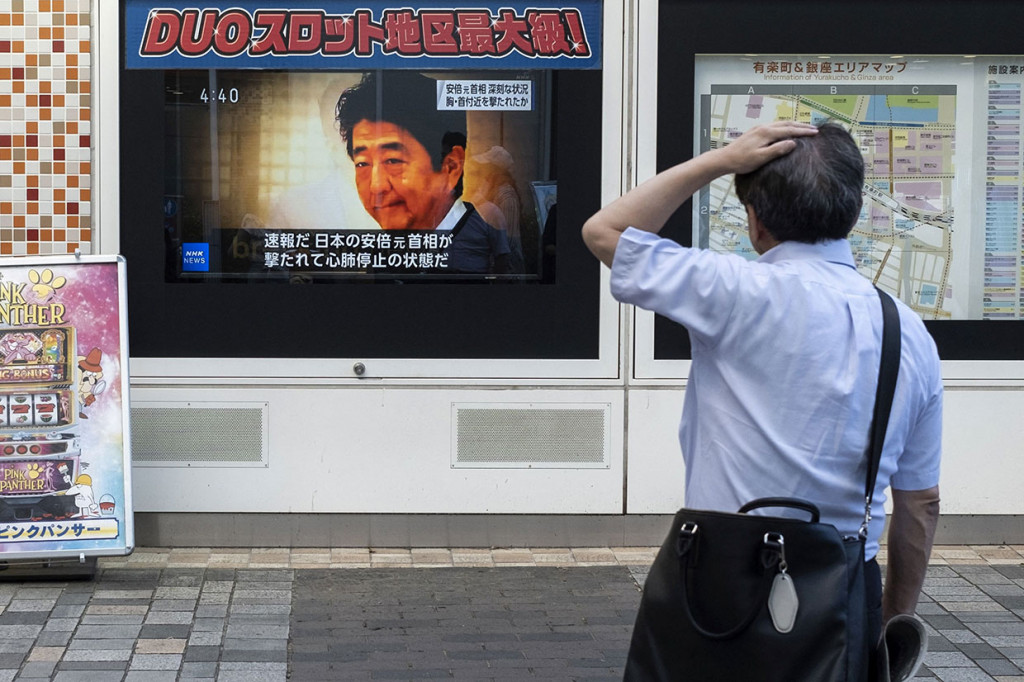 Seorang pria melihat siaran televisi yang menayangkan berita tentang penembakan terhadap mantan Perdana Menteri Jepang Shinzo Abe pada hari sebelumnya, di ruas jalan di Tokyo pada Jumat, 8 Juli 2022.