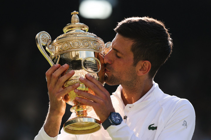 Novak Djokovic mencium trofi kemenangan usai meraih gelar juara nomor tunggal putra ajang Wimbledon 2022.