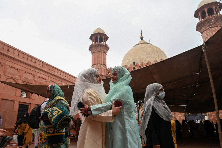 Para muslimah saling bersalaman usai melaksanakan salat Iduladha di Lahore pada 10 Juli 2022. AFP Photo/Arif Ali