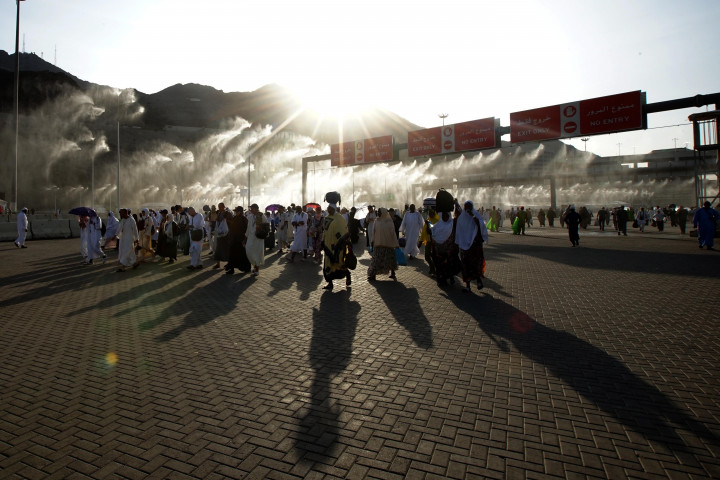 Jemaah haji berjalan melalui gerbang penyemprot air usai melakukan lempar Jumrah di Jamarat, Mina, Mekkah, Arab Saudi, Senin, 11 Juli 2022.