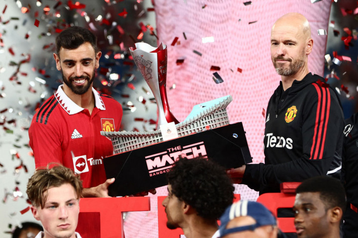 Manajer MU Erik Ten Hag dan gelandang Bruno Fernandes mengangkat trofi usai memenangi laga persahabatan melawan Liverpool.