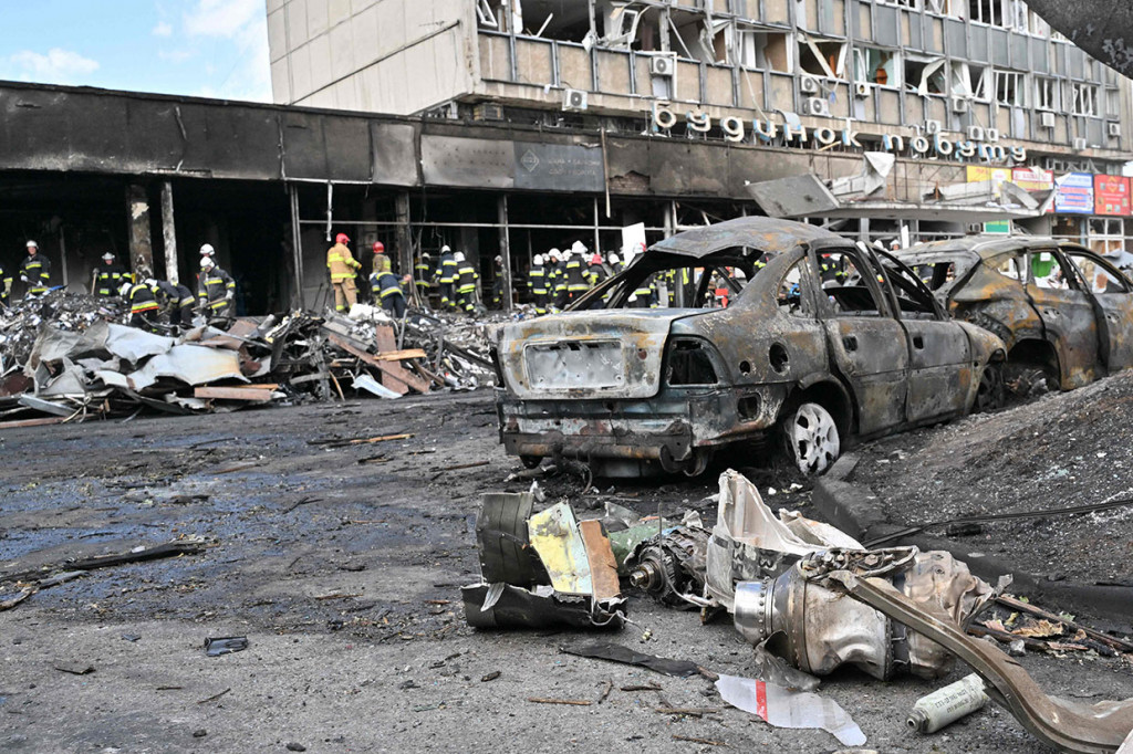 Sisa-sisa dari mobil yang hangus dan terbalik dikelilingi oleh puing-puing yang terbakar terlihat dalam gambar yang didistribusikan oleh pejabat, sementara asap cokelat mengepul di dekatnya.