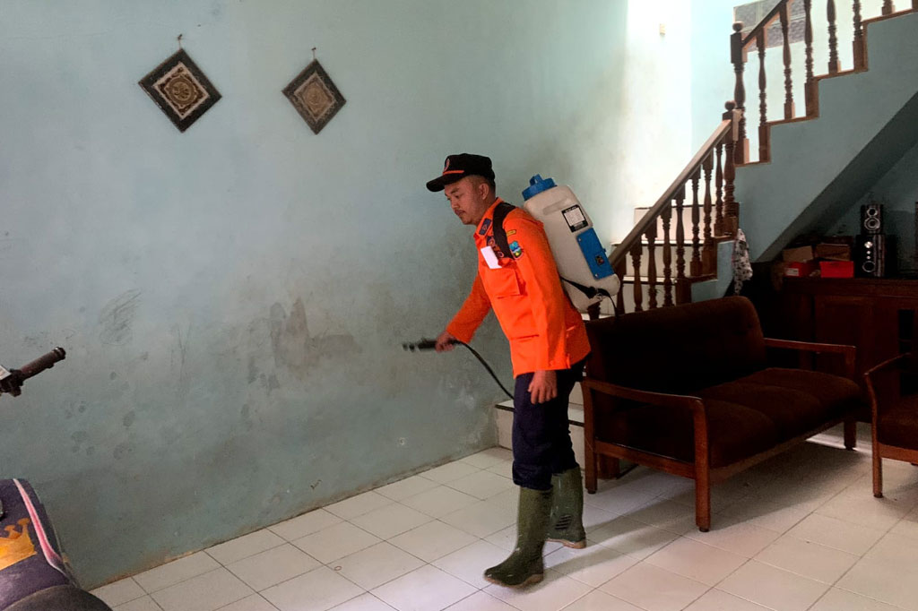 Petugas dan relawan bahu membahu membersihkan material banjir dan melakukan penyemprotan disinfektan di Kampung Ciwalen, Kecamatan Garut Kota, Kabupaten Garut, Selasa, 19 Juli 2022. 