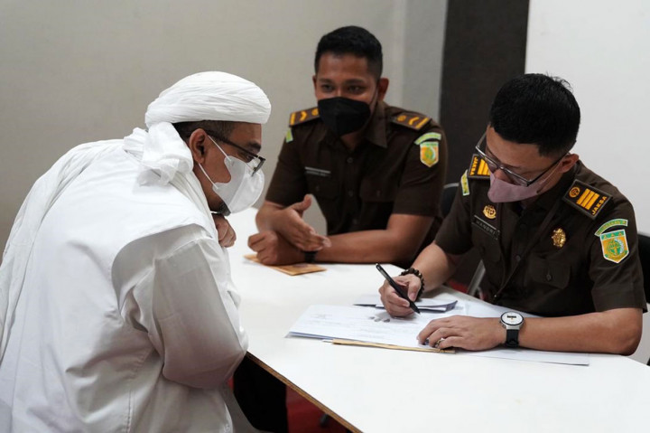 Mengenakan pakaian serba putih dan bermasker, Muhammad Rizieq Shihab menjalani proses administrasi pembebasan bersyarat.