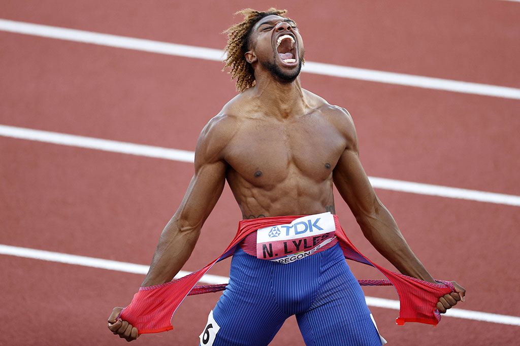 Lyles mengeluarkan raungan kegembiraan setelah melewati garis finis, sambil merobek jerseinya dengan gembira.