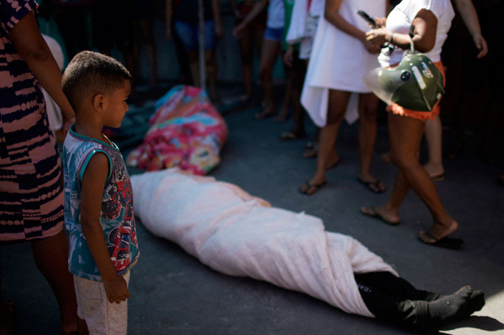Sejumlah jenazah terlihat ditutupi dengan selimut setelah warga membawanya ke jalan utama Complexo do Alemao sebelum dibawa ke rumah sakit, usai penggerebekan polisi di sebuah favela di Rio de Janeiro, Brasil, pada Kamis, 21 Juli 2022 waktu setempat.