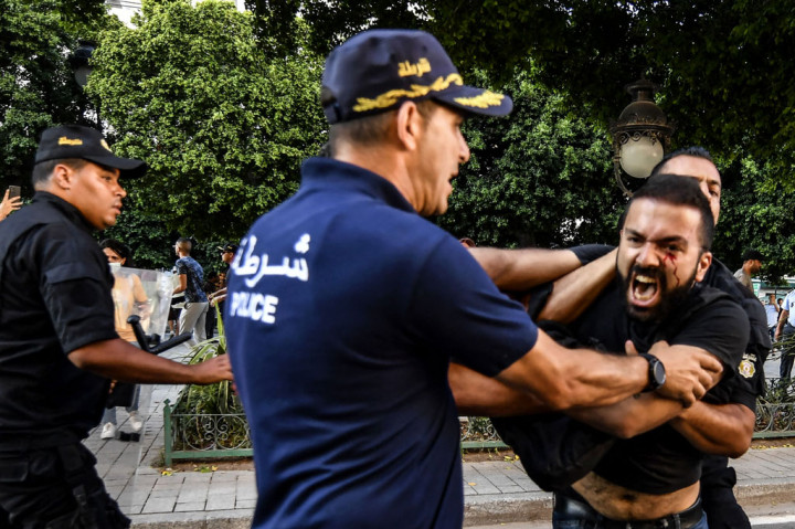 Polisi Tunisia menangkap seorang pengunjuk rasa pada 22 Juli 2022, selama demonstrasi menentang presiden dan referendum konstitusi 25 Juli mendatang di sepanjang jalan Habib Bourguiba di ibu kota Tunis.