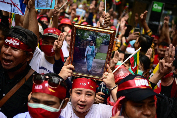 Para pengunjuk rasa menunjukkan salut tiga jari dan memegang foto pemimpin sipil Myanmar yang ditahan Aung San Suu Kyi selama demonstrasi menentang eksekusi empat tahanan junta militer Myanmar, di luar Kedutaan Besar Myanmar di Bangkok pada 26 Juli 2022.