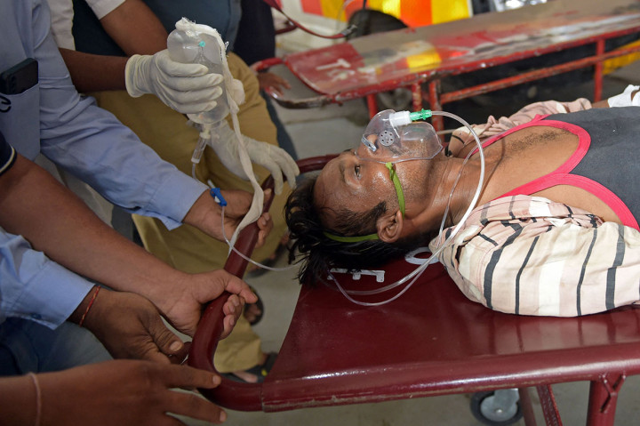 Seorang pria dipindahkan ke tandu saat tiba dengan ambulans di rumah sakit sipil di Ahmedabad pada 26 Juli 2022, setelah menderita masalah kesehatan karena mengonsumsi minuman keras oplosan.