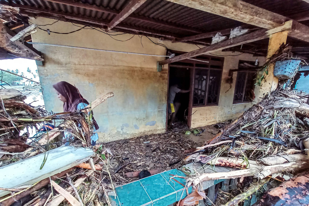 warga mengumpulkan sisa barang mereka dari puing rumah yang hancur akibat diterjang banjir bandang di Desa Torue, Kabupaten Parigi Moutong, Sulawesi Tengah, Jumat, 29 Juli 2022.