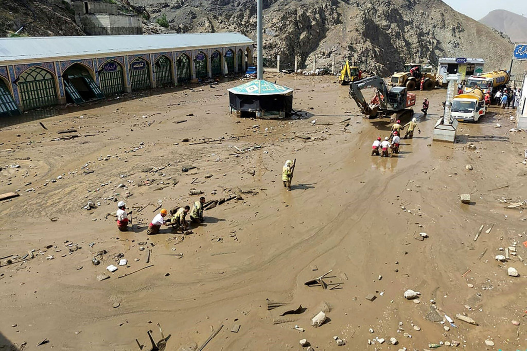 Anggota tim penyelamat mencari korban di lokasi banjir bandang di bagian barat Laut Emamzadeh Davoud, Teheran, Iran, Kamis, 28 Juli 2022.