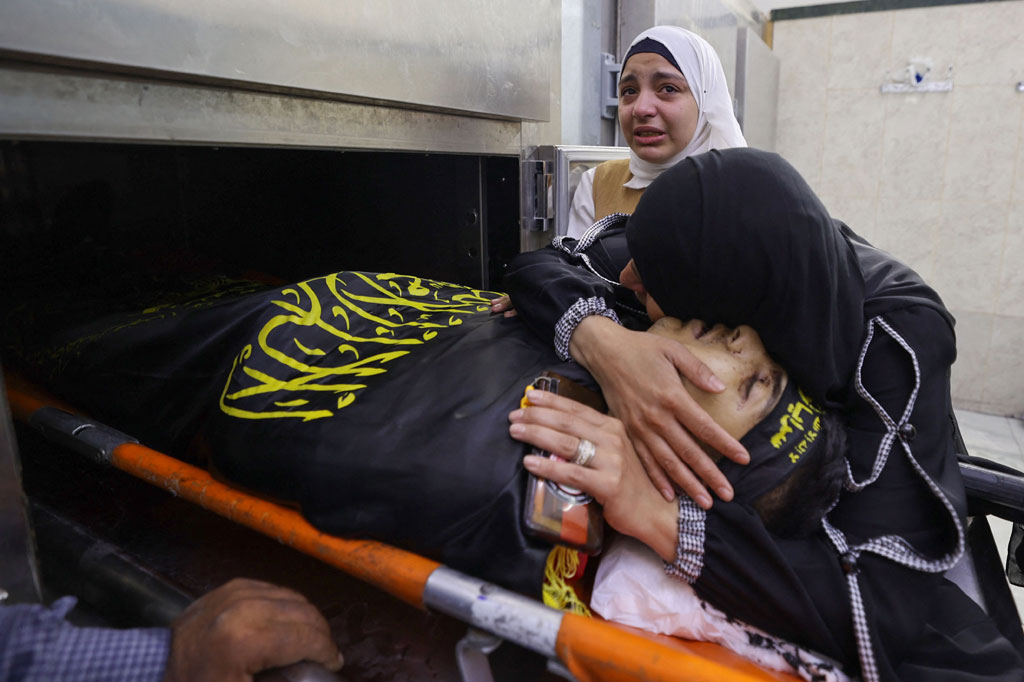 Kerabat memeluk jenazah Dhurar al-Kafrini Palestina, yang dilaporkan meninggal dalam bentrokan dengan pasukan Israel di kamp pengungsi Jenin, di kamar mayat rumah sakit Jenin, di Tepi Barat yang diduduki, pada Selasa, 2 Agustus 2022.