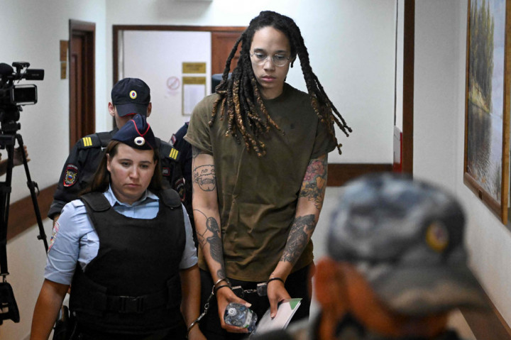 Pemain bola basket AS Brittney Griner (kanan) dikawal oleh polisi sebelum sidang pengadilan atas tuduhan penyelundupan narkoba, di Khimki, di luar Moskow pada Selasa, 2 Agustus 2022.