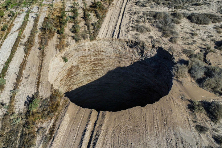 Pemandangan udara diambil pada 1 Agustus 2022, menunjukkan sinkhole raksasa yang muncul pada akhir pekan di dekat kota pertambangan Tierra Amarilla, Provinsi Copiapo, di Gurun Atacama, Chili.