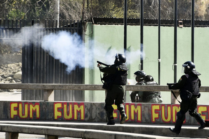 Polisi anti huru hara menembakkan gas air mata ke arah petani daun koka selama bentrokan di La Paz, Bolivia pada 4 Oktober 2021.