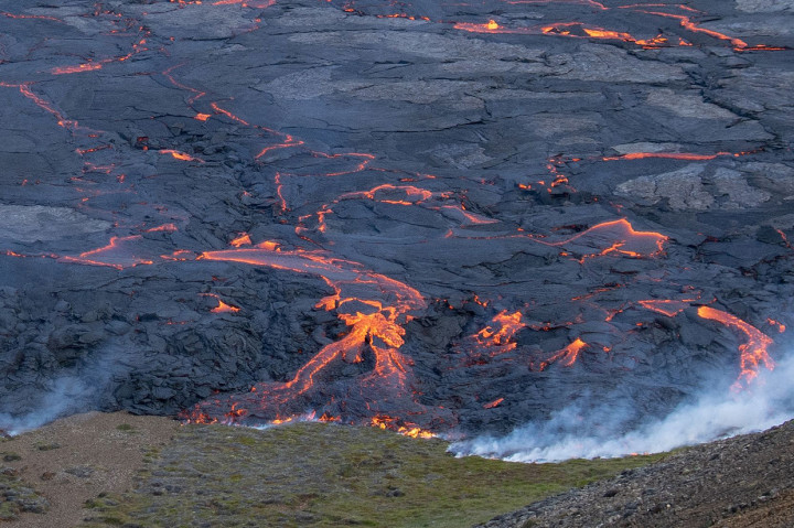 Percikan lava yang keluar dari gunung berapi tersebut. Lava tersebut terlihat berwarna merah oranye.