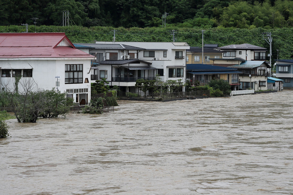 Hujan deras yang mengguyur utara Jepang membanjiri jalan dan menyebabkan sungai meluap. 