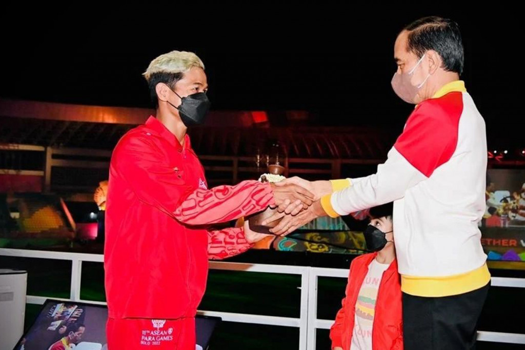 Usai memberikan sambutan, Presiden Jokowi secara simbolis menyerahkan kendi berisi air kepada salah seorang atlet renang difabel Jendi Pangabean, kemudian diserahkan ke tokoh Hanoman.