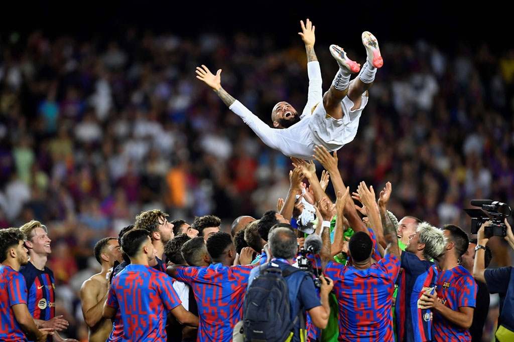 Para pemain Barcelona mengangkat tinggi-tinggi mantan rekan setim mereka Dani Alves yang kini merumput bersama Pumas.