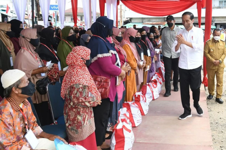 Presiden Joko Widodo didampingi Ibu Iriana Joko Widodo menyerahkan Bantuan Modal Kerja (BMK) dan Bantuan Langsung Tunai (BLT) minyak goreng kepada peserta Program Keluarga Harapan (PKH) di Pasar Sungai Duri, Kabupaten Bengkayang, Provinsi Kalimantan Barat, pada Selasa, 9 Agustus 2022.