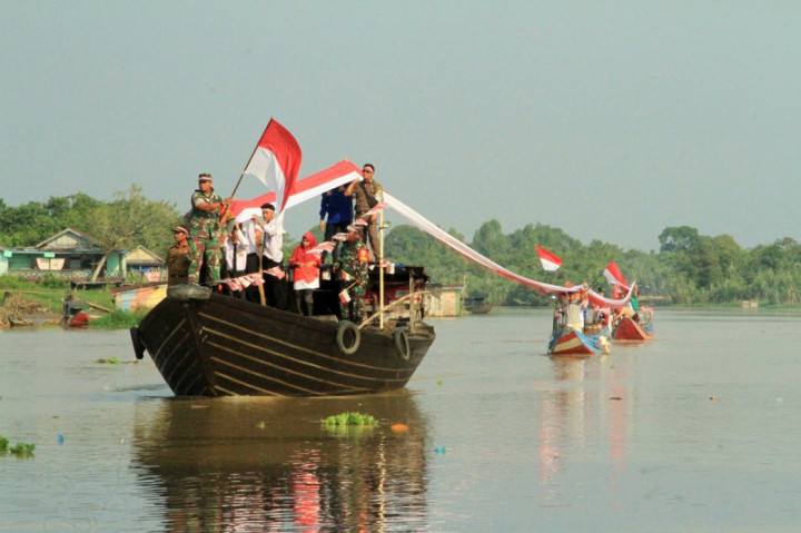 Forkopimcam dan organisasi kepemudaan dan sejumlah unsur masyarakat di Bayung Lencir, Musi Banyuasin membentangkan 177 meter bendera merah putih dan membagikan 177 buah bendara merah putih.