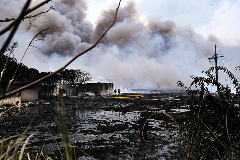 Petugas pemadam kebakaran bekerja di daerah di mana kebakaran hebat di depot bahan bakar yang dipicu oleh sambaran petir terjadi di Matanzas, Kuba, pada Selasa, 9 Agustus 2022 waktu setempat.