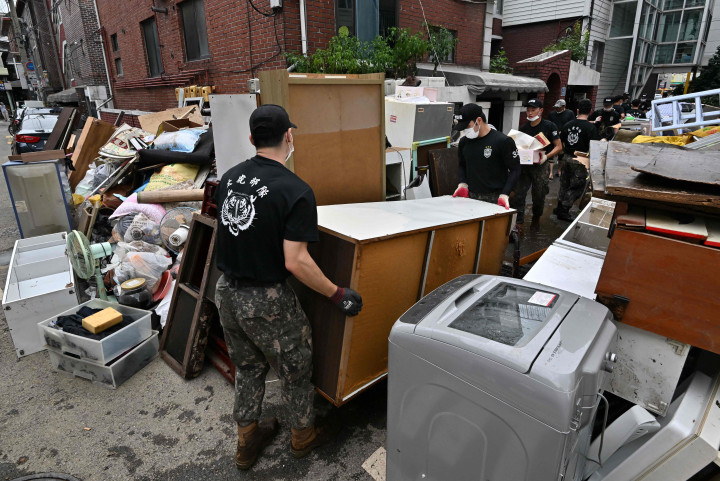 Tentara Korea Selatan membersihkan puing-puing dari daerah perumahan di Seoul pada 10 Agustus 2022, setelah banjir parah yang melanda wilayah tersebut.