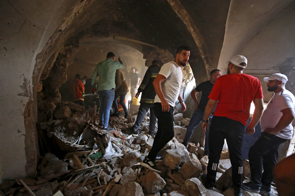Warga Palestina menggeledah sebuah rumah untuk mengevakuasi jenazah warga Palestina yang tewas dalam serangan Israel, di kota Nablus, Tepi Barat, pada 9 Agustus 2022.
