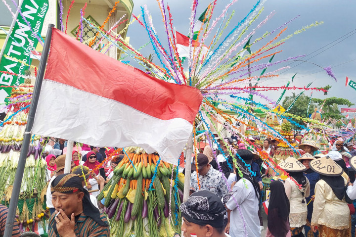Warga mengarak gunungan yang berisi hasil bumi dalam tradisi kirab budaya di Desa Karangrowo, Kecamatan Undaan, Kabupaten Kudus, Jawa Tengah, Sabtu, 13 Agustus 2022.