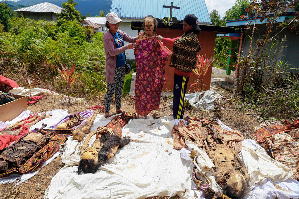 Kerabat mengganti pakaian jenazah keluarganya saat ritual Manene di Lembang Ampang Batu, Kabupaten Toraja Utara, Sulawesi Selatan, Senin, 15 Agustus 2022.