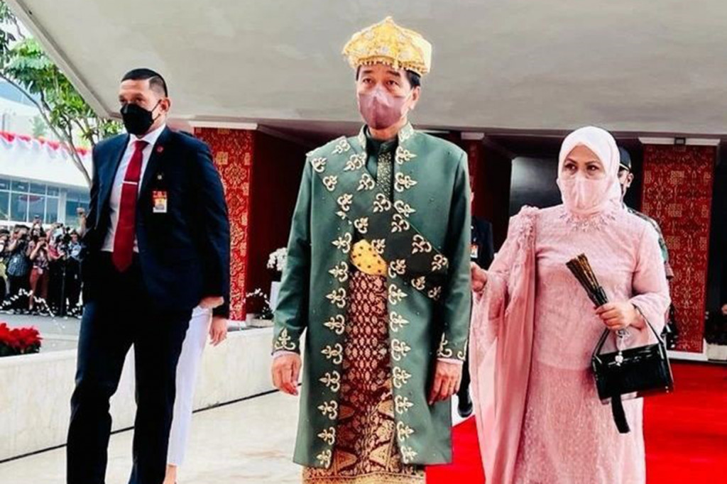 Sementara itu, Ibu Iriana tampil anggun dengan mengenakan kebaya berwarna pink lengkap dengan hijab berwarna senada. Penampilan Ibu Iriana tersebut dilengkapi dengan kain batik berwarna cokelat. 
