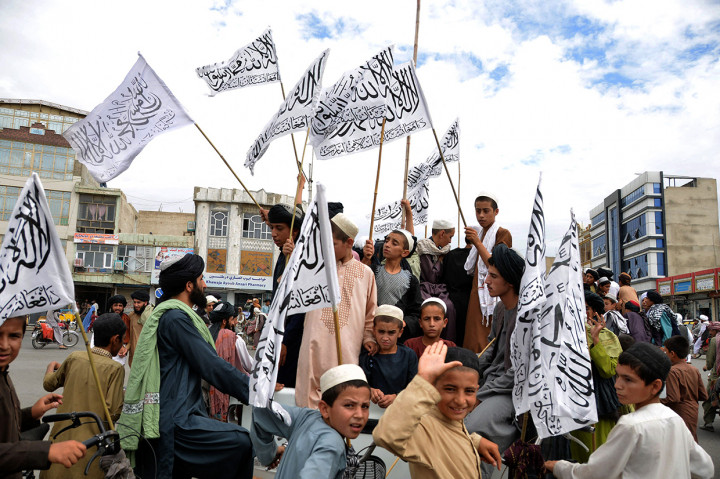 Anggota Taliban memegang bendera Imarah Islam Afghanistan pada peringatan setahun berkuasa di Kabul, Afghanistan, Senin, 15 Agustus 2022.