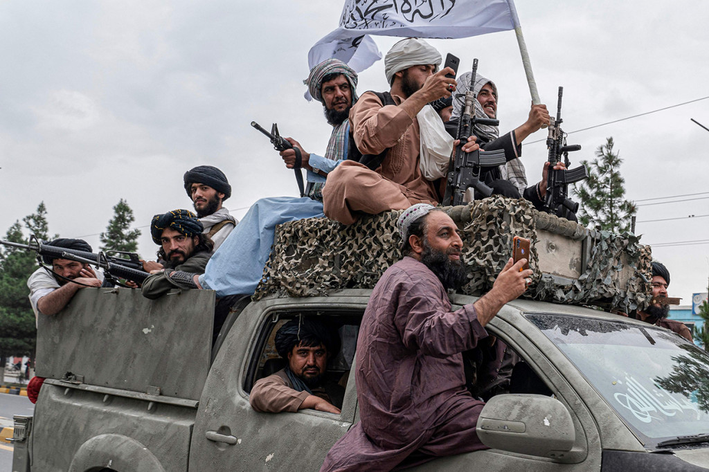 Mereka merayakan ulang tahun pertama kembalinya Taliban ke puncak kekuasaan di Kabul, Afghanistan di sebelah kedutaan besar Amerika Serikat. Para anggota berkumpul dan memegang senjata.