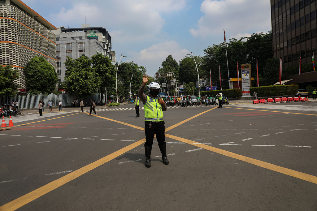 Petugas kepolisian memandu pengendara untuk menghentikan kendaraannya saat peringatan detik-detik Proklamasi Kemerdekaan RI di Jalan MH Thamrin, Jakarta, Rabu, 17 Agustus 2022. 