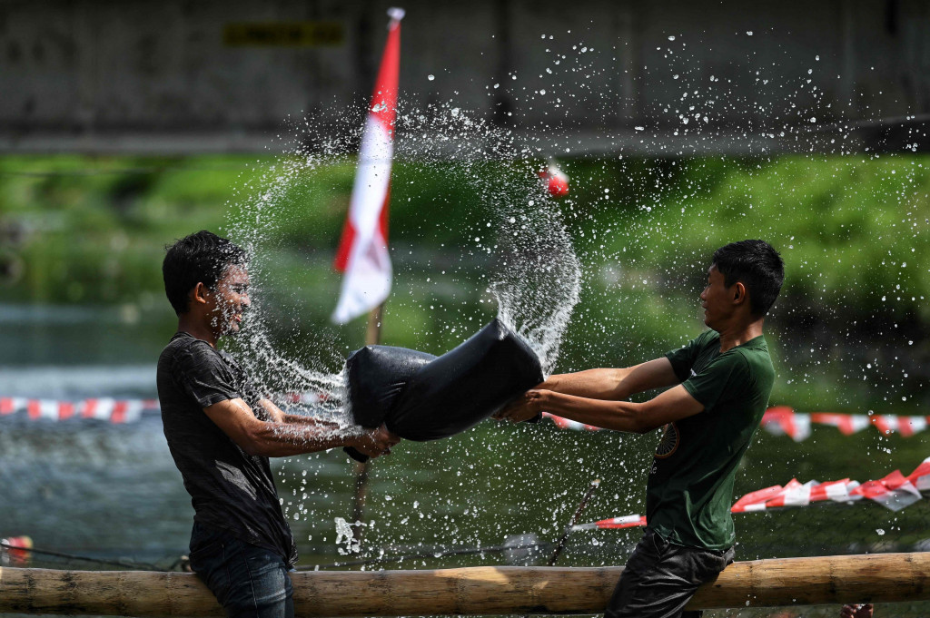 Di Banda Aceh, sejumlah warga mengikuti beragam lomba seperti lomba perang bantal, menangkap bebek, hingga bermain sepeda di atas sungai.