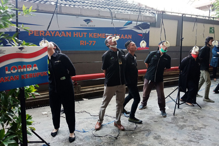 Peserta berlomba untuk menghabiskan kerupuk dalam lomba makan kerupuk.