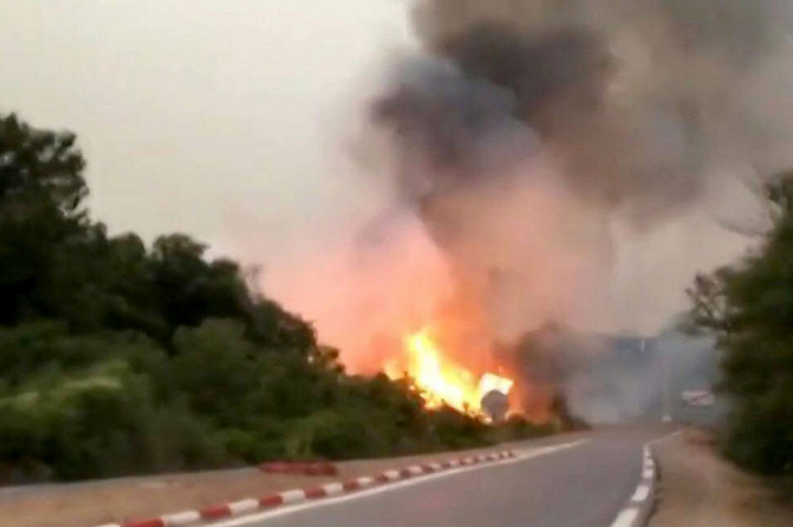Asap mengepul dari api besar yang mengamuk di sisi jalan menuju Kota Souarekh, di Provinsi El Tarf, Aljazair pada Rabu, 17 Agustus 2022.