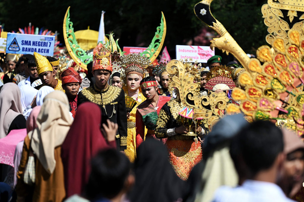 Peserta karnaval menggunakan pakaian kreasi adat saat mengikuti pawai karnaval dalam rangka memperingati HUT ke-77 RImelintas di Lapangan Blang Padang, Banda Aceh, Kamis, 18 Agustus 2022.
