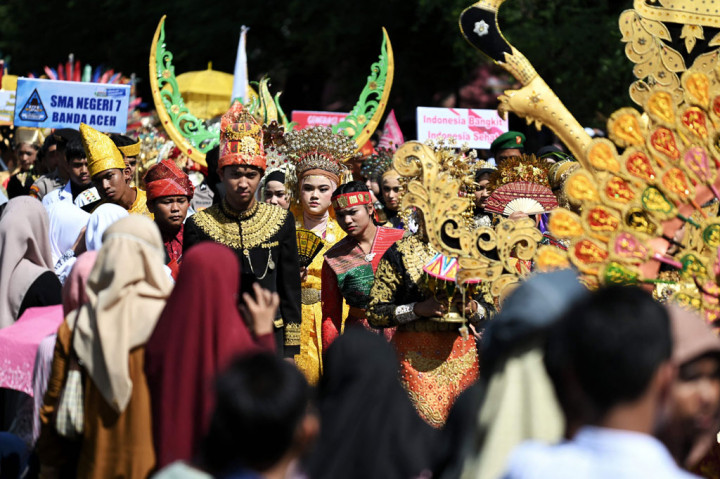 Peserta karnaval menggunakan pakaian kreasi adat saat mengikuti pawai karnaval dalam rangka memperingati HUT ke-77 RImelintas di Lapangan Blang Padang, Banda Aceh, Kamis, 18 Agustus 2022.