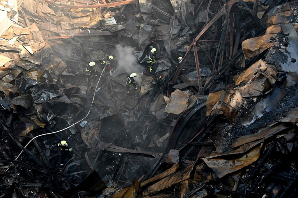 Petugas pemadam kebakaran bekerja di antara reruntuhan bangunan Istana Budaya yang hancur akibat serangan rudal tentara Rusia di Kota Kharkiv, Ukraina, Kamis, 18 Agustus 2022. 