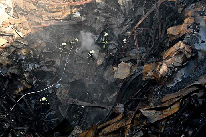 Petugas pemadam kebakaran bekerja di antara reruntuhan bangunan Istana Budaya yang hancur akibat serangan rudal tentara Rusia di Kota Kharkiv, Ukraina, Kamis, 18 Agustus 2022. 