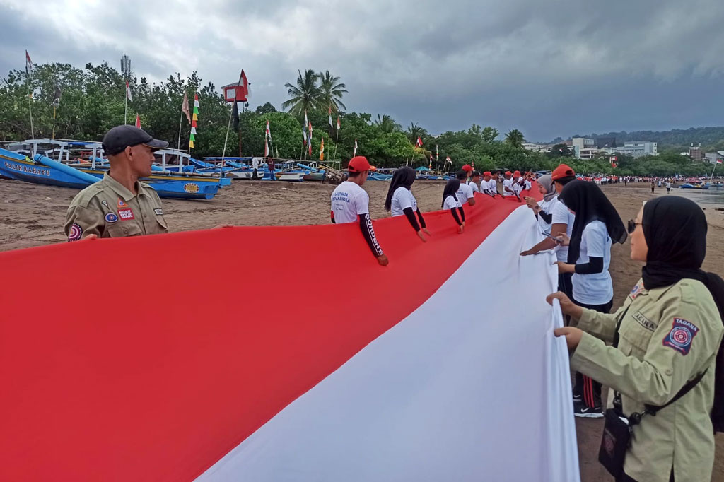Bendera merah putih sepanjang 1.000 meter tersebut dibentangkan dari Pantai Barat, kemudian diarak sejauh 5 km hingga Pantai Timur, Pangandaran.