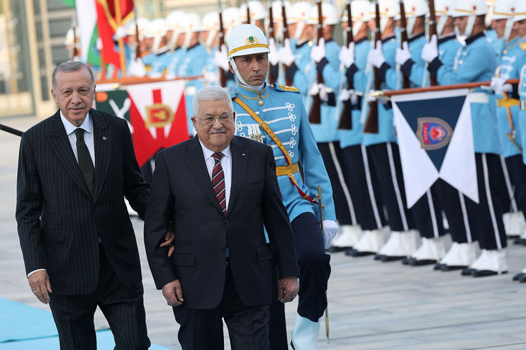 Presiden Turki Recep Tayyip Erdogan (kiri) menggandeng Presiden Palestina Mahmoud Abbas (tengah) sebelum pertemuan mereka dalam upacara penyambutan resmi di Kompleks Kepresidenan di Ankara, pada Selasa, 23 Agustus 2022 waktu setempat.