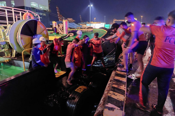 Personel penjaga pantai membantu penumpang yang selamat (memakai jaket pelampung) setelah kapal feri yang mereka tumpangi terbakar, di pelabuhan Batangas, Filipina, Jumat, 26 Agustus 2022.