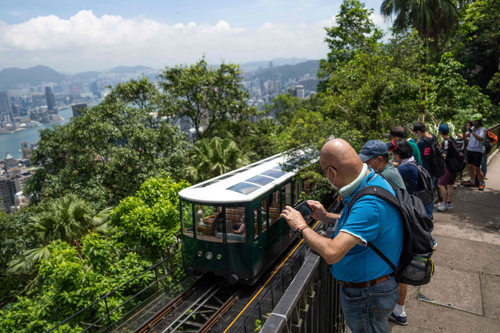 Orang-orang mengambil gambar Peak Tram generasi keenam yang baru direnovasi pada hari pertama beroperasi di Hong Kong pada Sabtu, 27 Agustus 2022.