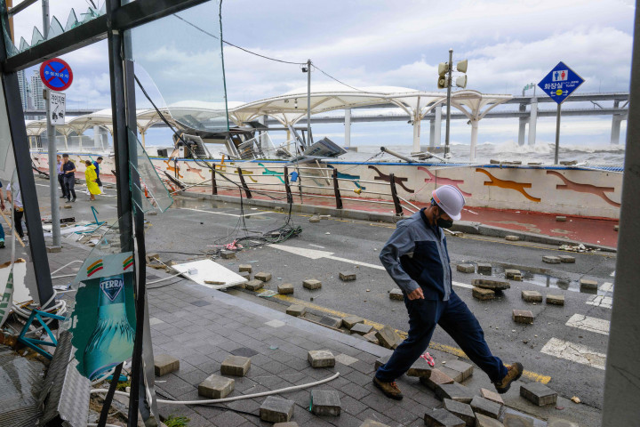 Terjangan topan Hinnamnor di Busan memicu ombak besar dan hujan deras, yang memicu kerusakan pada ruas jalanan dan pertokoan di tepi pantai.