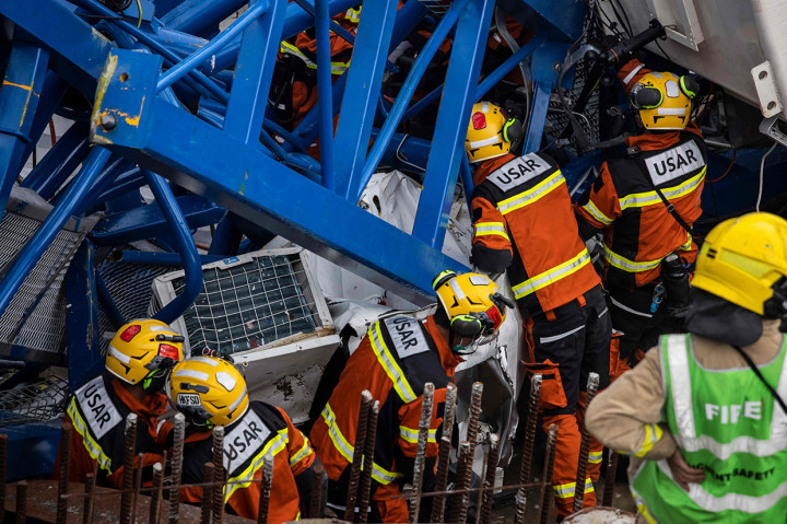 Anggota tim Urban Search And Rescue (USAR) (kiri) bekerja di lokasi runtuhnya crane di Hong Kong pada Rabu, 7 September 2022, di mana dua orang meninggal dunia dan enam lainnya terluka di lokasi konstruksi. 