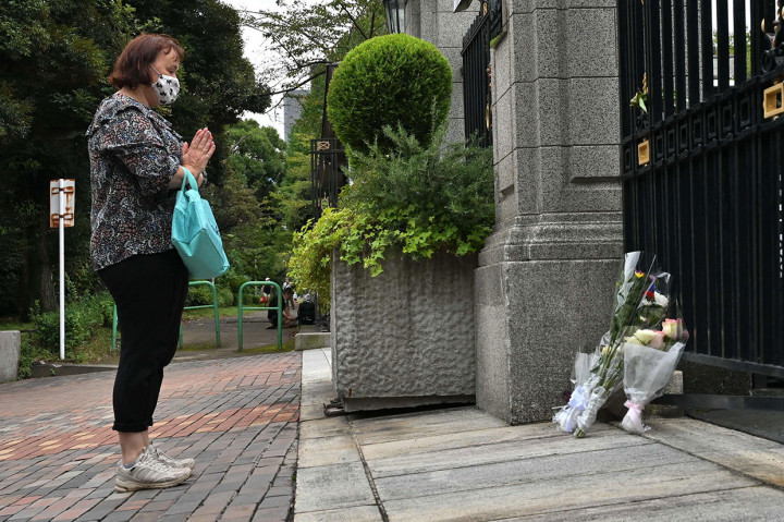 Seorang wanita berdoa di samping karangan bunga di luar Kedutaan Inggris untuk Jepang, setelah kematian Ratu Inggris Elizabeth II, di Tokyo pada Kamis, 9 September 2022.