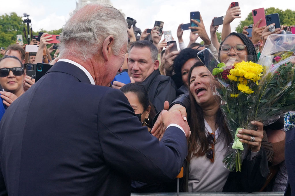 Raja Charles mendapat ciuman dari seorang peremuan dan beberapa bunga dari massa yang menyemut menyambut kedatangannya di Istana Buckingham, London, Jumat, 9 September 2022.